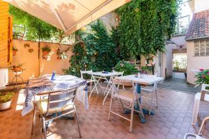 un patio al aire libre con mesas, sillas y plantas en B&B La Gatta Blu, en Cattolica