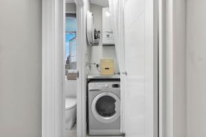 a bathroom with a toilet and a washing machine at Modern Double bedroom in city apartment room 1 in London