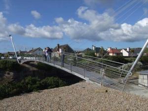 a bridge over a river with people walking on it at Barber’s hall town center apartment in Belmullet