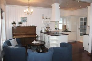 a kitchen with blue chairs and a table and a counter at Skipperhus Skjærhalden in Skjærhollen