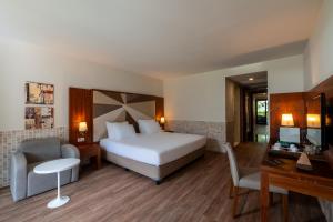 a bedroom with a bed and a desk and a chair at Nirvana Mediterranean Excellence - Ultra All Inclusive in Beldibi