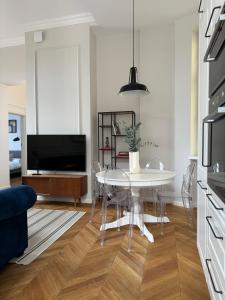 uma sala de estar com uma mesa e uma televisão em Wilson Apartamenty em Poznań