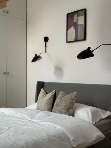 um quarto com uma cama com duas luzes na parede em Wilson Apartamenty em Poznań
