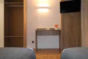 a room with a desk and a television in a room at Hostal Alda Palencia Plaza in Palencia