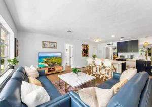 a living room with a blue couch and a kitchen at Stunning 3 Bedroom Home In Naples in Naples
