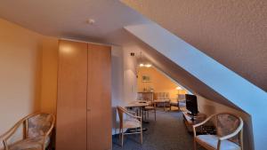 Zimmer mit einer Treppe mit einem Tisch und Stühlen in der Unterkunft Hotel Peenebrücke in Wolgast