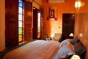 a bedroom with two beds and two windows at Riad Adarissa in Fez