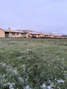 un campo de hierba con un edificio en el fondo en Casas Rurales Cuatro Valles, en Naredo de Fenar