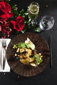 une assiette de nourriture sur une table avec des roses dans l'établissement Hotel Narvil Conference & Spa, à Serock