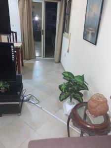 - un salon avec une télévision et une table dans l'établissement شقة سكنية ذات طابع عائلى متميز بها كافة الامكانيات من فلتر ماء وواى فاى, à Hurghada
