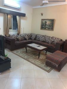 a living room with a couch and a coffee table at شقة سكنية ذات طابع عائلى متميز بها كافة الامكانيات من فلتر ماء وواى فاى in Hurghada