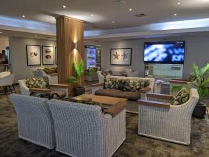 a living room with wicker furniture and a tv at Breakers Resort, Umhlanga in Durban