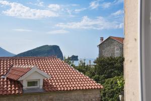 a view of a roof of a house with mountains in the background at Royal Garden Apartments & Gastronomy in Budva