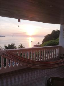 a hammock on a balcony looking out at the ocean at La casa de Wili Taboga 62,61,00,07 in Taboga