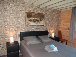 een slaapkamer met een bed en een stenen muur bij B&B Le bruissement in Bièvre