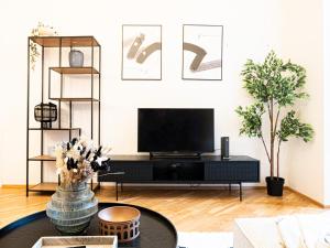 een woonkamer met een tv en een tafel bij Cozy Industrial 8min Dancing House APT in Praag