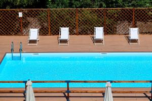 a row of chairs and a swimming pool with lounge chairs at Occidental Aurelia in Rome