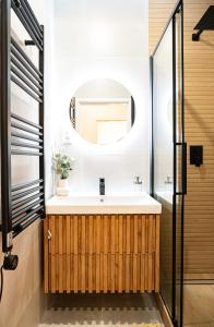 een badkamer met een wastafel en een spiegel bij Cozy Industrial 8min Dancing House APT in Praag