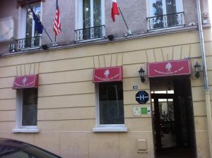 a building with flags on the side of it at Hôtel du Parc in Malakoff