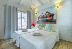 アデへにあるVilla Karla by Villas Vista Gomeraのベッドが2つあり、壁に絵が飾られた寝室 +26枚の写真