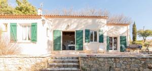 une maison blanche avec un mur en pierre dans l'établissement Les Olivettes - Maison très calme Parking privé, à Régusse