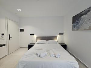 a bedroom with a bed with two towels on it at Adele Hotel Ksamil in Ksamil