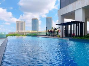 a swimming pool with a city skyline in the background at MONIC STAYCATION #Southkey Mosaic next to Mid Valley Mall in Johor Bahru