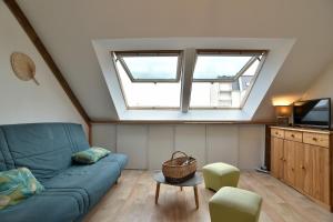 uma sala de estar com um sofá azul e uma janela em Landes - Appartement vue mer à 150m de la plage em Saint-Cast-le-Guildo