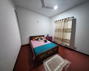 Un dormitorio con una cama y una ventana. en Villa kresilda, en Gampola