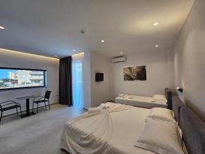 ein Schlafzimmer mit 2 Betten und einem Tisch darin in der Unterkunft Adele Hotel Ksamil in Ksamil