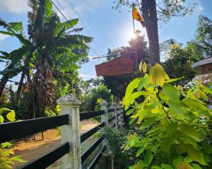 Un jardín con una valla y un cartel. en Villa kresilda, en Gampola