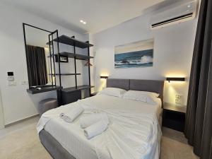 a bedroom with a large white bed with two pillows at Adele Hotel Ksamil in Ksamil
