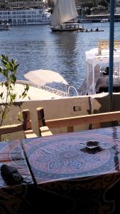 een tafel met een bord aan de zijkant van een boot bij Onaty Narty Guest house in Aswan