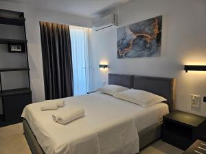 a bedroom with a bed with two towels on it at Adele Hotel Ksamil in Ksamil