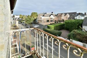 einen Balkon mit Blick auf eine Straße und Häuser in der Unterkunft Bruyères - Appartement vue mer à 150m de la plage in Saint-Cast-le-Guildo