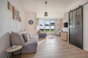 a living room with a couch and a table at Appartement pour 4 avec grand jardin in Préfailles