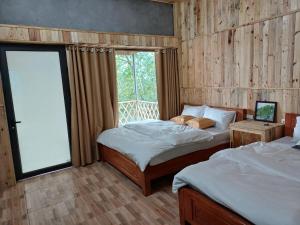 een slaapkamer met 2 bedden en een raam bij Hill House in Mai Chau