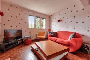 uma sala de estar com um sofá vermelho e uma televisão em Séjour pour 4 à Sarzeau em Sarzeau