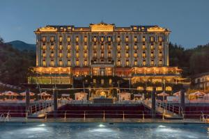 um grande edifício com uma fonte em frente em Grand Hotel Tremezzo em Tremezzo