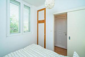 biała sypialnia z łóżkiem i oknem w obiekcie Lero Sea View Apartment w Dubrowniku