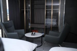 a room with two chairs and a table and a bed at プラフィーノリゾートヴィラ in Ise