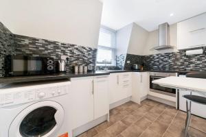 a kitchen with a washer and dryer in it at Stunning Double Rooms within a Loft space in London