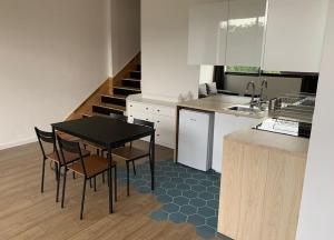 een keuken met een tafel en stoelen en een trap bij Studio indépendant dans maison in Couzon-au-Mont-dʼOr
