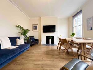 a living room with a blue couch and a table at 4 Bed Apartment- Archway Station in London