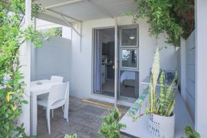 a small patio with a white table and chairs at Lily's Rest, Village on Silwerstrand, Robertson in Robertson