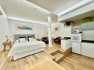 Cet appartement comprend une chambre avec un lit blanc et une cuisine. dans l'établissement LOFT CENTRE SANTANDER, à Santander