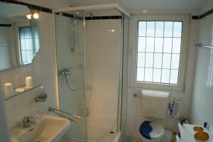 ein Badezimmer mit Dusche, Toilette und Waschbecken in der Unterkunft Graf Luckner Hüs in Scharbeutz
