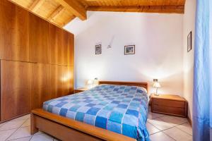 1 dormitorio con 1 cama con manta de cuadros azul en Casella's apartment 1, en Malcesine