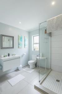 a white bathroom with a shower and a toilet at Lily's Rest, Village on Silwerstrand, Robertson in Robertson