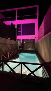 a large swimming pool with pink lighting in a building at درة العروس فيلا بشاطئ رملي خاص in Durat  Alarous